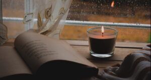 candle, open book, rainy window