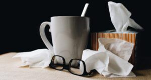 a photo of kleenex, glasses, and mug of tea