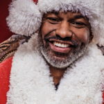 a photo of a smiling Black man with a short grey beard in a Santa outfit